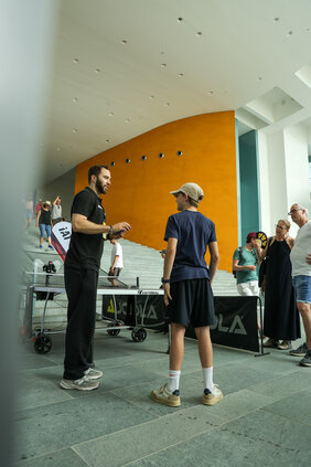 Wissenschaftler mit Besucher an der Tischtennisplatte